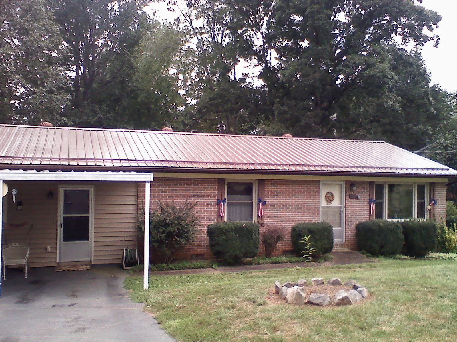 Bronze metal roof and carport on a brick ranch home — Roof Repair work by our crew in Bossier City