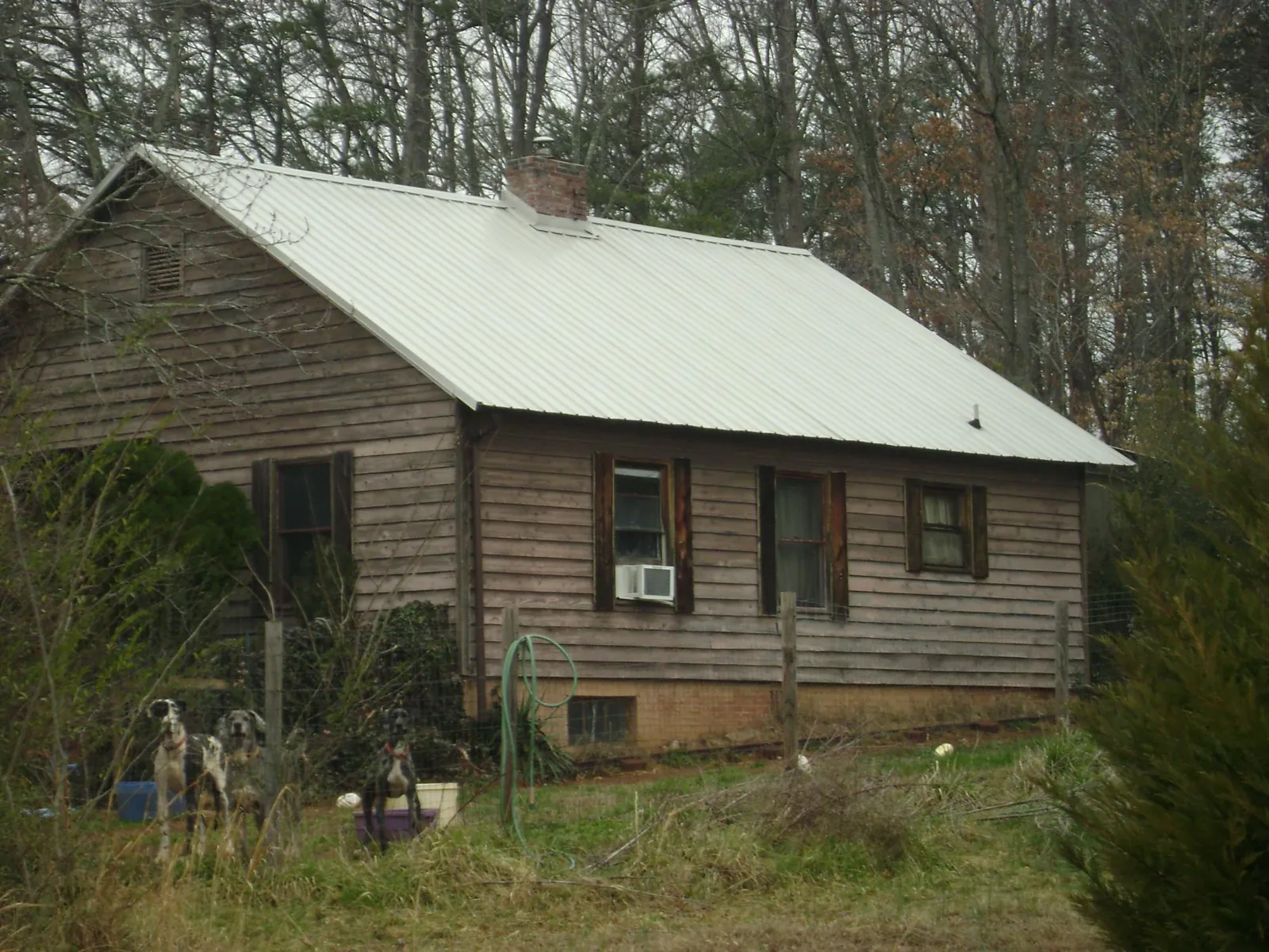 White metal roof on an old wood sided farmhouse, from a Asphalt Shingle Roof Repair job in Bossier City